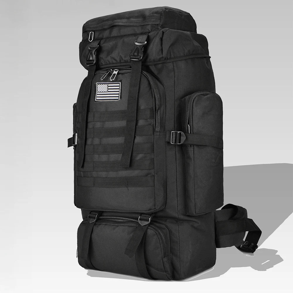 Black tactical backpack with American flag patch on a light gray background