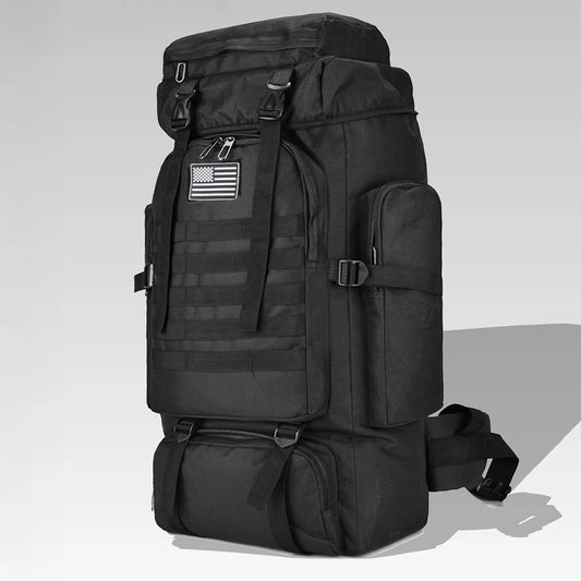 Black tactical backpack with American flag patch on a light gray background